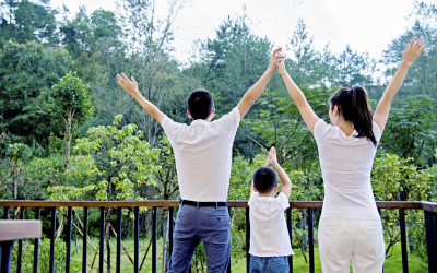 family of three with arms in the air